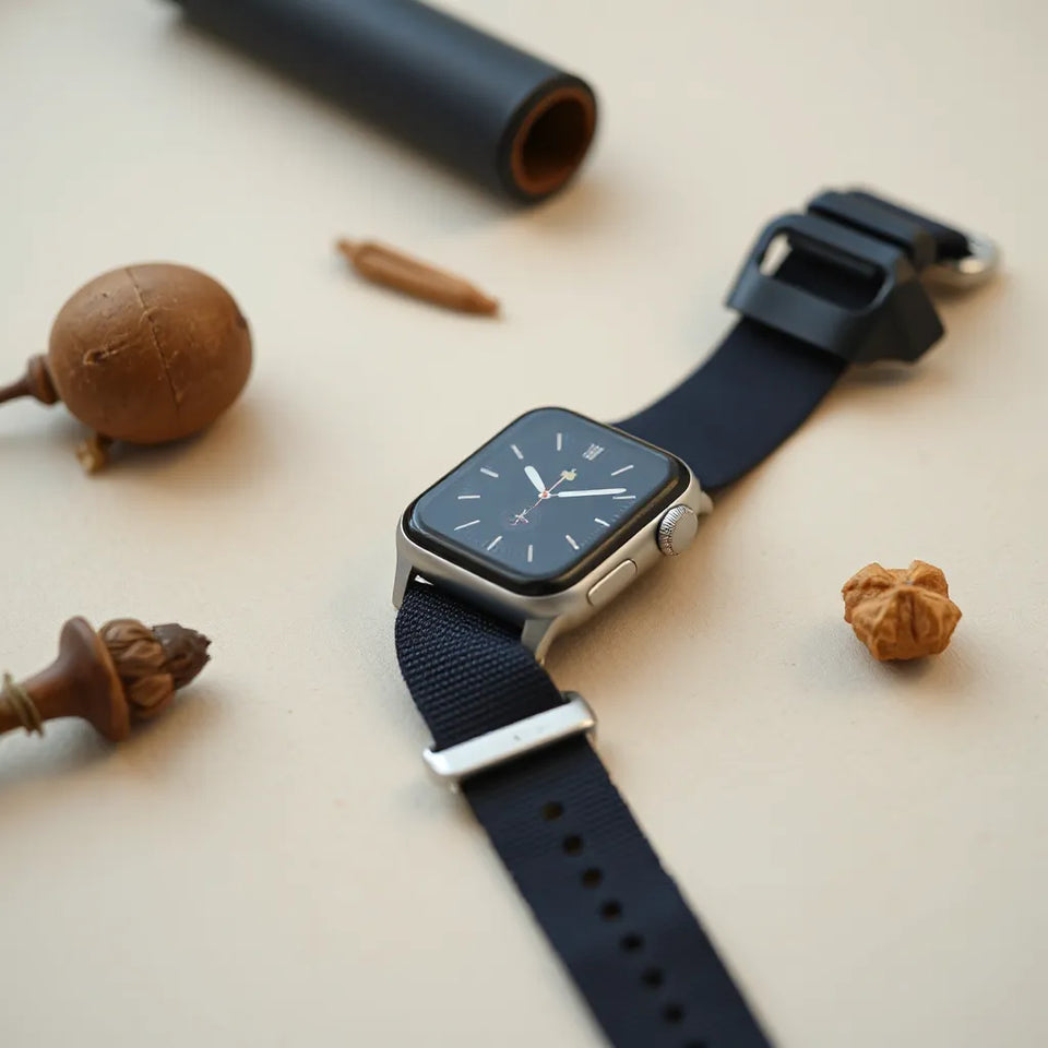 Apple Watch with a breathable nylon watch band and a couple of matching band options on a neutral background